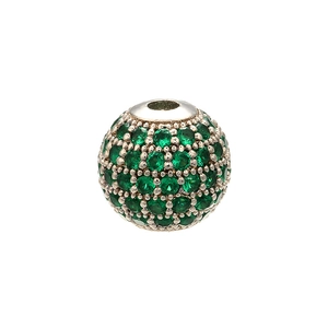 Macro detail of round copper bead with micro-paved green crystals for DIY jewelry