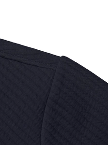 Detailed close-up of shoulder seam stitching and corduroy texture on navy blue sweatshirt