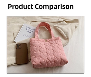 Detail of pink heart-quilted tote bag featuring a gold metal snap closure on soft fabric
