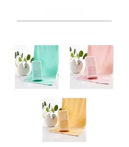 Detail of pure cotton towels in mint green, pink, and yellow with geometric jacquard pattern