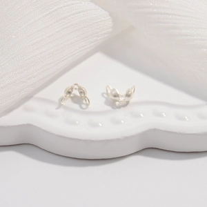 Detailed view of two S925 sterling silver jewelry fold-over crimp end clasps on white plate