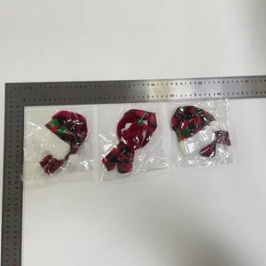 Three sets of mini Christmas hats and plaid scarves in red and black with ruler reference