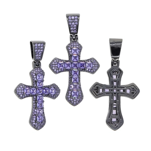 Macro shot of hip hop cross pendants with purple zircon insets and black metal finish