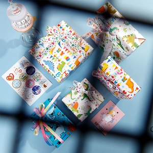 Birthday gift wrapping set with cartoon dinosaur paper, colorful ribbons and greeting cards