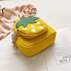Detail of yellow canvas kids crossbody bag featuring cute strawberry shape and leaf decor