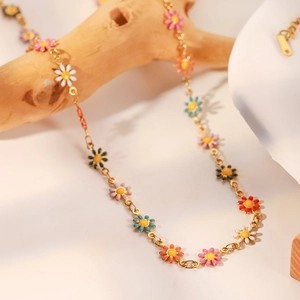 Detalle del collar de cadena de oro de 18K con colgantes de margaritas de esmalte de color