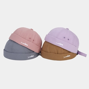 Detail of four colorful miki hats with whale embroidery and premium cotton texture