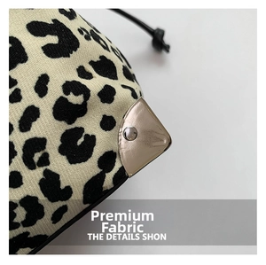 Macro view of leopard print fabric texture and silver metal corner protector on bag