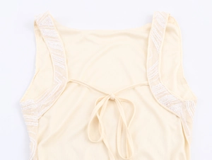 Detail view of beige sequined dress back with elegant lace-up bow and shimmering beads