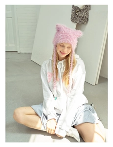 Detailed view of pink fuzzy cat ear trapper hat with long fluffy earflaps for winter