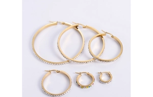 Detail view of various sizes of gold hoop earrings with sparkling crystal accents
