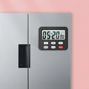 Macro view of digital kitchen timer with magnetic back attached to a silver refrigerator
