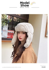 Detailed view of plush beige trapper hat with soft faux fur texture and earflap buckle