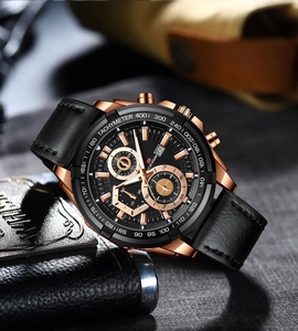 Detail of rose gold racing watch with black leather strap and tachymeter bezel