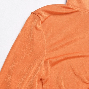 Detailed close-up of orange glossy fabric with vertical texture and precise stitching detail