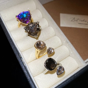 Selection of cubic zirconia rings with triangle and pear cuts in gold and silver finish