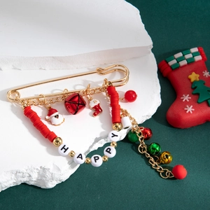 Broche de Noël festive avec perles HAPPY, clochettes dorées et breloques sur bloc blanc