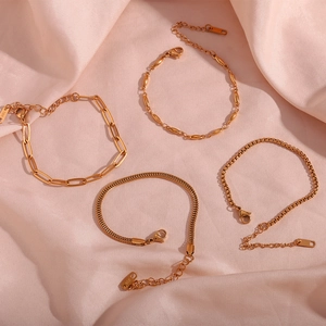 Detailed view of four 18K gold plated stainless steel chain styles on pink satin fabric