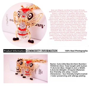 Detail shot of golden bee keychain with red and black enamel and rhinestones