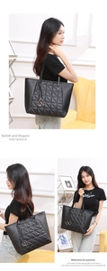 Detail of black tote bag featuring triangular quilted pattern and metal ring charms