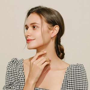 Elegant S925 sterling silver hoop earrings with turquoise stones worn by a model