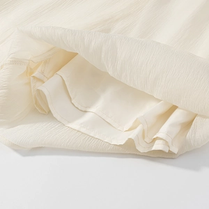 Detail of creamy white crinkle fabric with smooth lining and premium stitching craftsmanship