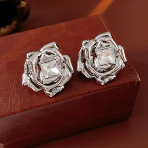 Vue macro détaillée de boucles d'oreilles rose en argent avec zircon sur cuir brun