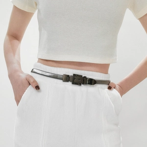 Detail of silver spring metal waist belt with dark square buckle on a model