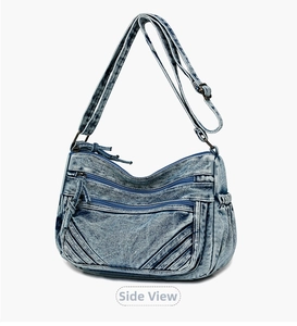Detail of light blue denim crossbody bag with multiple zippers and adjustable strap