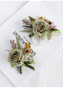 Macro detail of vintage green rose wrist corsage and boutonniere for wedding guests