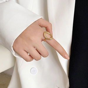 Close-up of minimalist 18k gold-plated stainless steel oval open ring worn on a hand