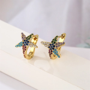 Macro detail of gold starfish earrings set with colorful blue and purple zircon stones