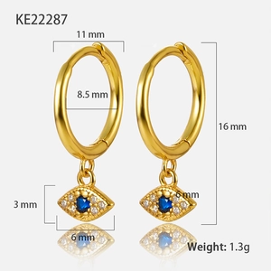 Macro shot of gold evil eye hoop earrings with blue stone and dimension details
