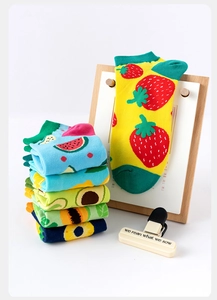 Detail shot of colorful fruit patterned mid-calf socks with strawberry and avocado designs