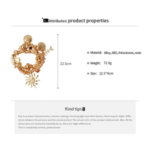 Detailed view of multilayer gold bracelet with sea shell, starfish and sun charms