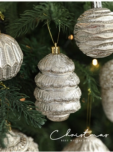 Primo piano dell'ornamento a torre d'argento scintillante appeso a un albero di Natale decorato