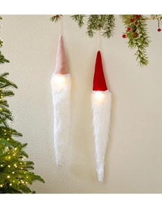 Detail of plush Christmas gnome ornaments with long white beards and warm LED light globes