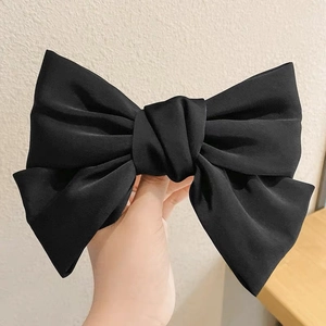 Large black satin bow hair clip with multi-layered fabric ribbons and elegant texture