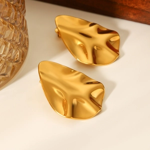 Macro shot of 18k gold plated stainless steel earrings with irregular hammered texture