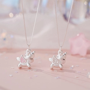 Close-up of matte silver unicorn pendant with pink wings and fine box chain