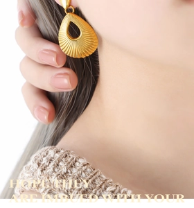 Detail of gold teardrop earrings featuring sunburst texture and center hollow design