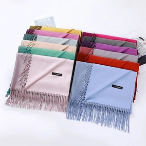 Detailed macro shot of various cashmere scarf colors with fringed edges and soft texture