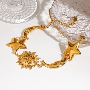 Celestial 18K gold stainless steel bracelet with sun, moon, and star charms on white background