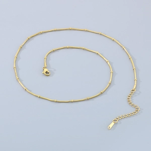 Detail of adjustable gold snake chain necklace with round beads and lobster clasp
