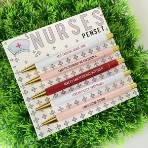 Close-up of funny nurse penset with slogans on cards over green grass background