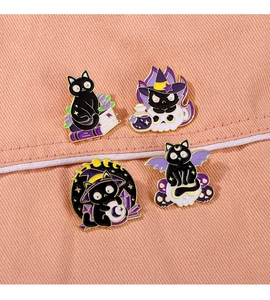 Set of four black cat enamel pins featuring magic themes on pink denim background