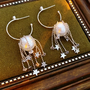 Créoles en argent avec pampilles d'étoiles et perles sur un cadre vert vintage