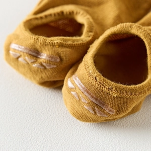 Macro shot of mustard yellow cotton socks with anti-slip silicone strips on the heel