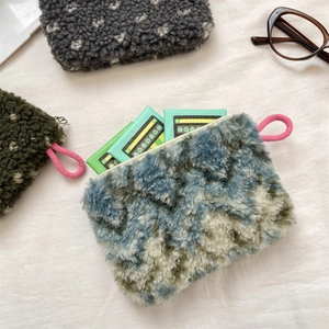 Top view of plush lamb wool storage pouches with zippers and colorful lanyards