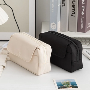 Dettaglio di astucci minimalisti in nylon impermeabile color beige e nero